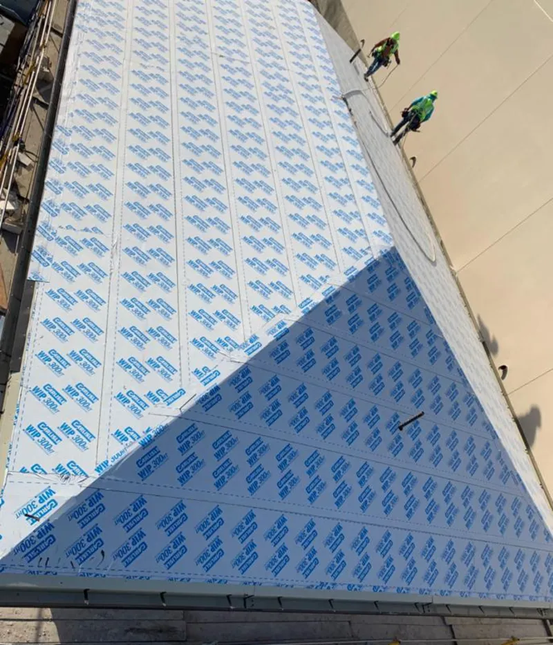 Professional roofers installing underlayment on a metal roof in Detroit